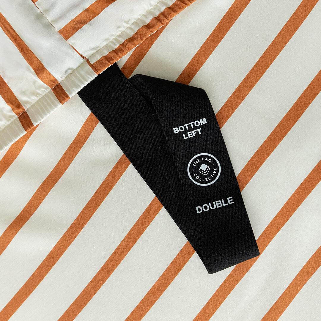 Black tag with text and a logo on a striped fabric background