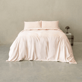 Blush pink quilt cover set styled on a modern bed with matching pillowcases, featuring a soft drape, elegant finish, and minimalist bedroom aesthetic.