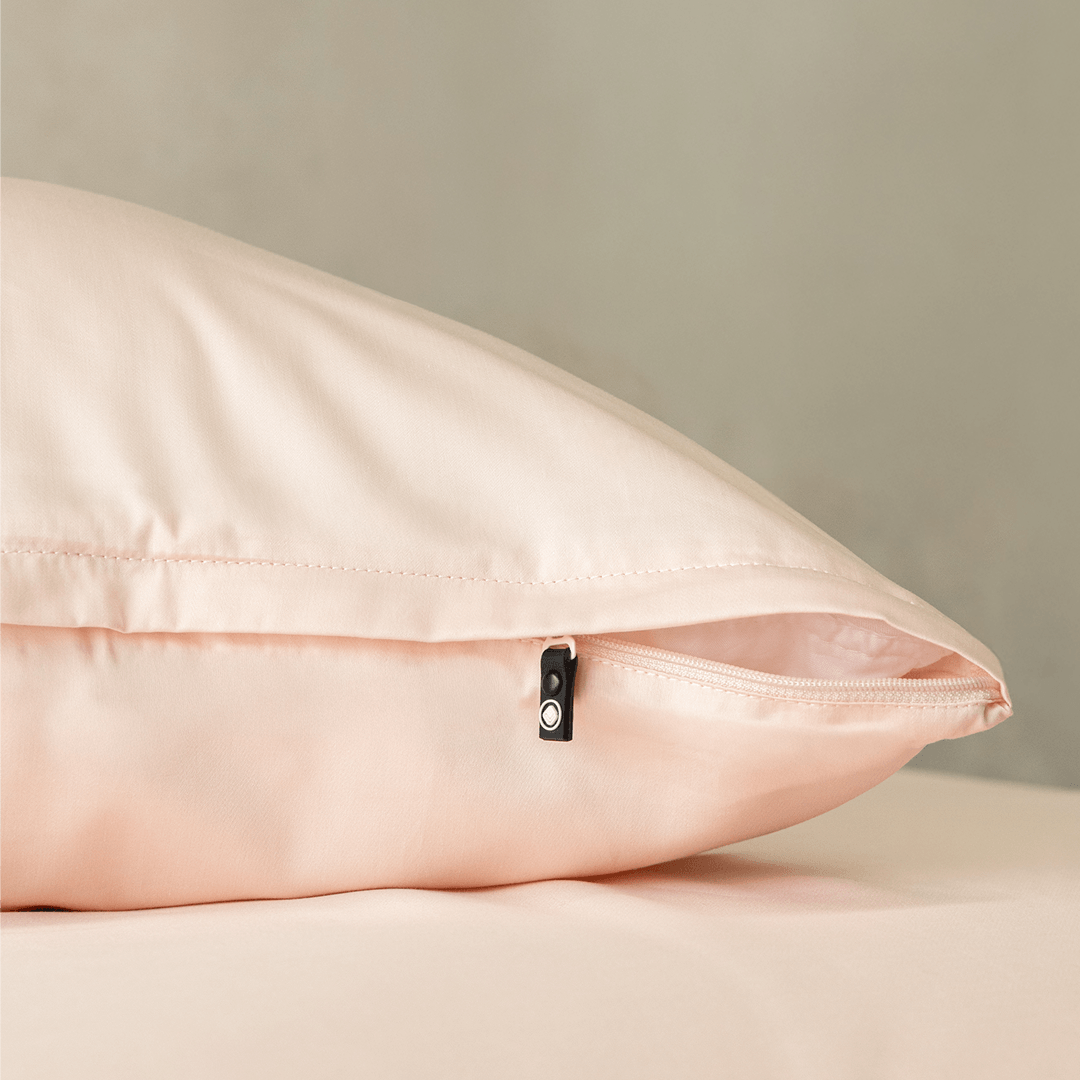 Close-up of a blush pink pillowcase featuring a concealed zipper closure, highlighting the secure fastening detail and soft, elegant fabric finish.