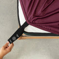 Close up or corner strap being pulled in deep maroon