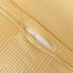 Close-up detail of a yellow waffle-weave quilt cover with an open zipper closure revealing white insert material