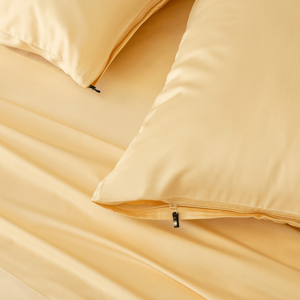 Close-up detail of pale yellow pillowcases showing hidden zipper closures