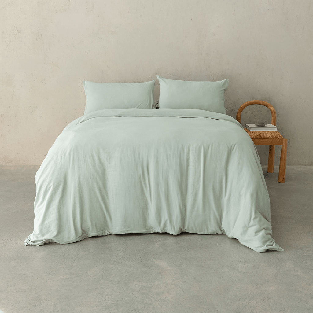 Sage green quilt cover set styled on a contemporary bed with matching pillowcases, showcasing a relaxed texture, soft drape, and calming bedroom aesthetic.