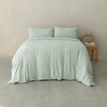 Sage green quilt cover set styled on a contemporary bed with matching pillowcases, showcasing a relaxed texture, soft drape, and calming bedroom aesthetic.