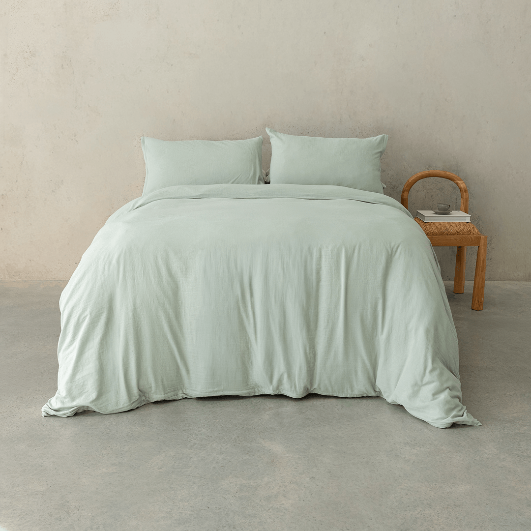 Sage green quilt cover set styled on a contemporary bed with matching pillowcases, showcasing a relaxed texture, soft drape, and calming bedroom aesthetic.