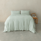 Sage green quilt cover set styled on a contemporary bed with matching pillowcases, showcasing a relaxed texture, soft drape, and calming bedroom aesthetic.