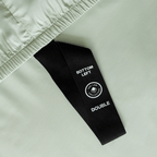 Detailed view of the fitted sheet corner label, showing the size indicator and orientation tag designed for easier bed making.