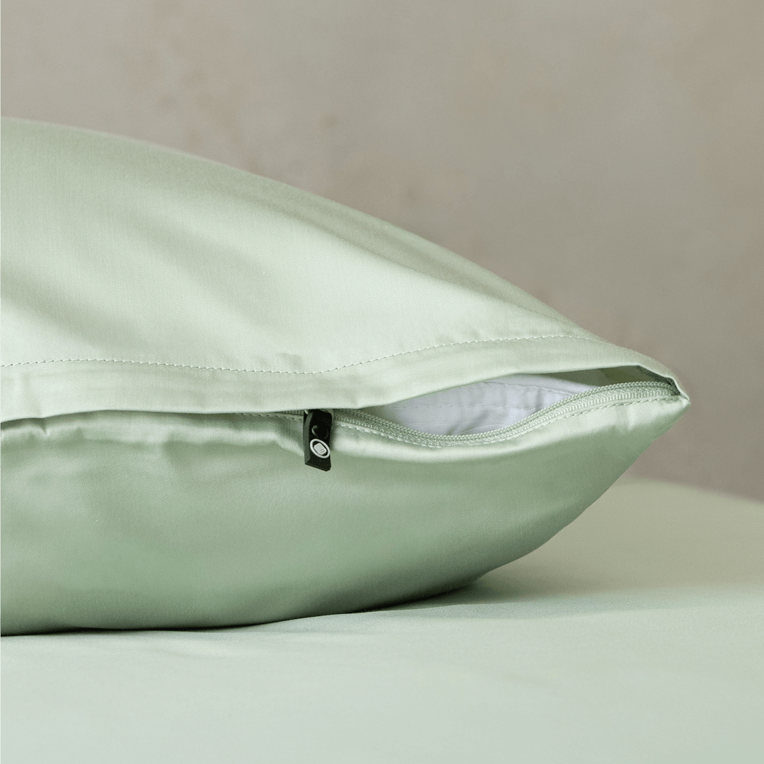 Detailed view of a sage green pillowcase with concealed zipper closure, showcasing the smooth fabric finish and premium construction.