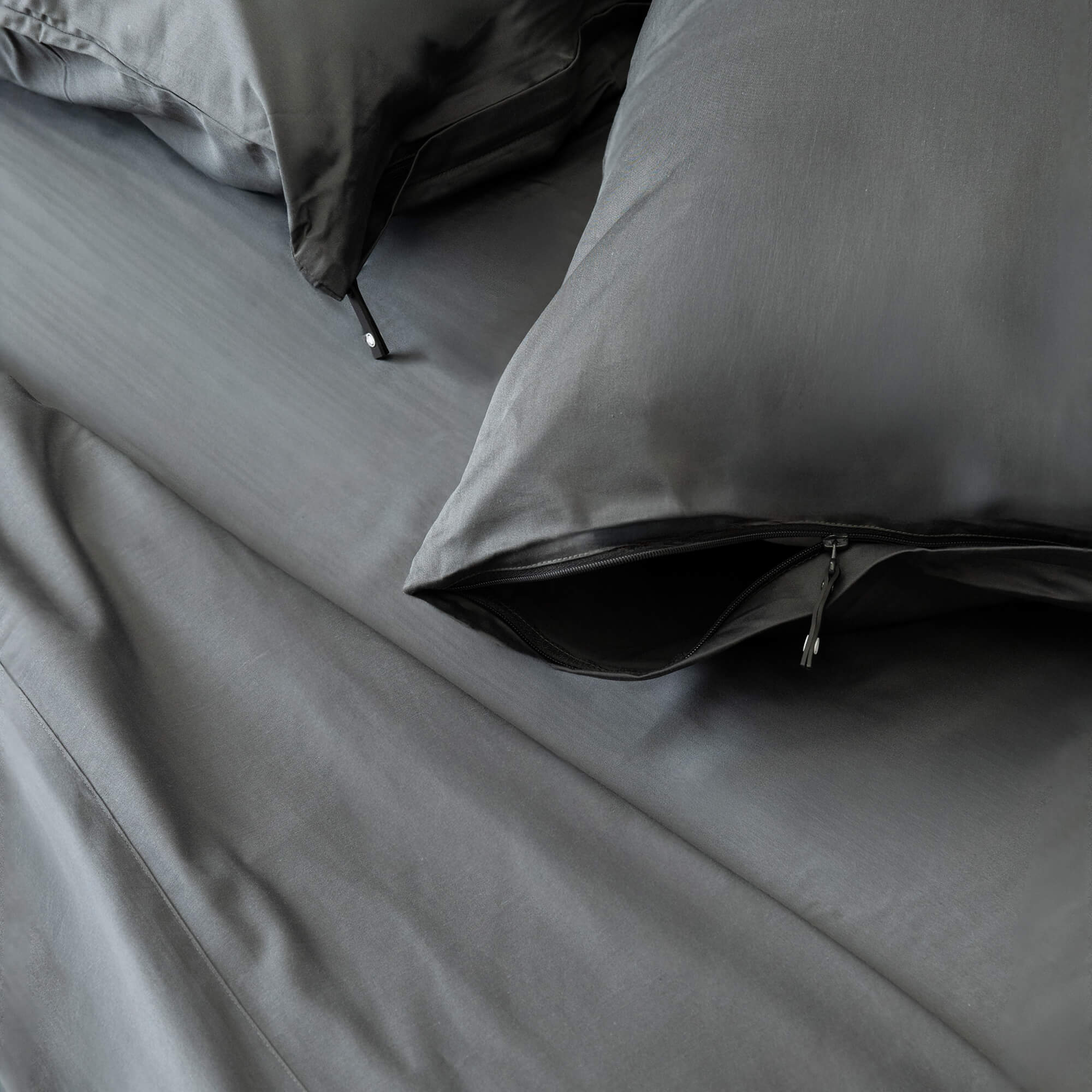 Gray bedding set with pillows on a bed