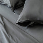 Gray bedding set with pillows on a bed