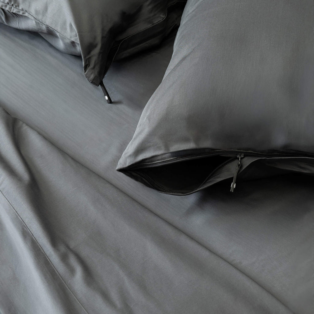 Grey bedding set with pillows on a bed