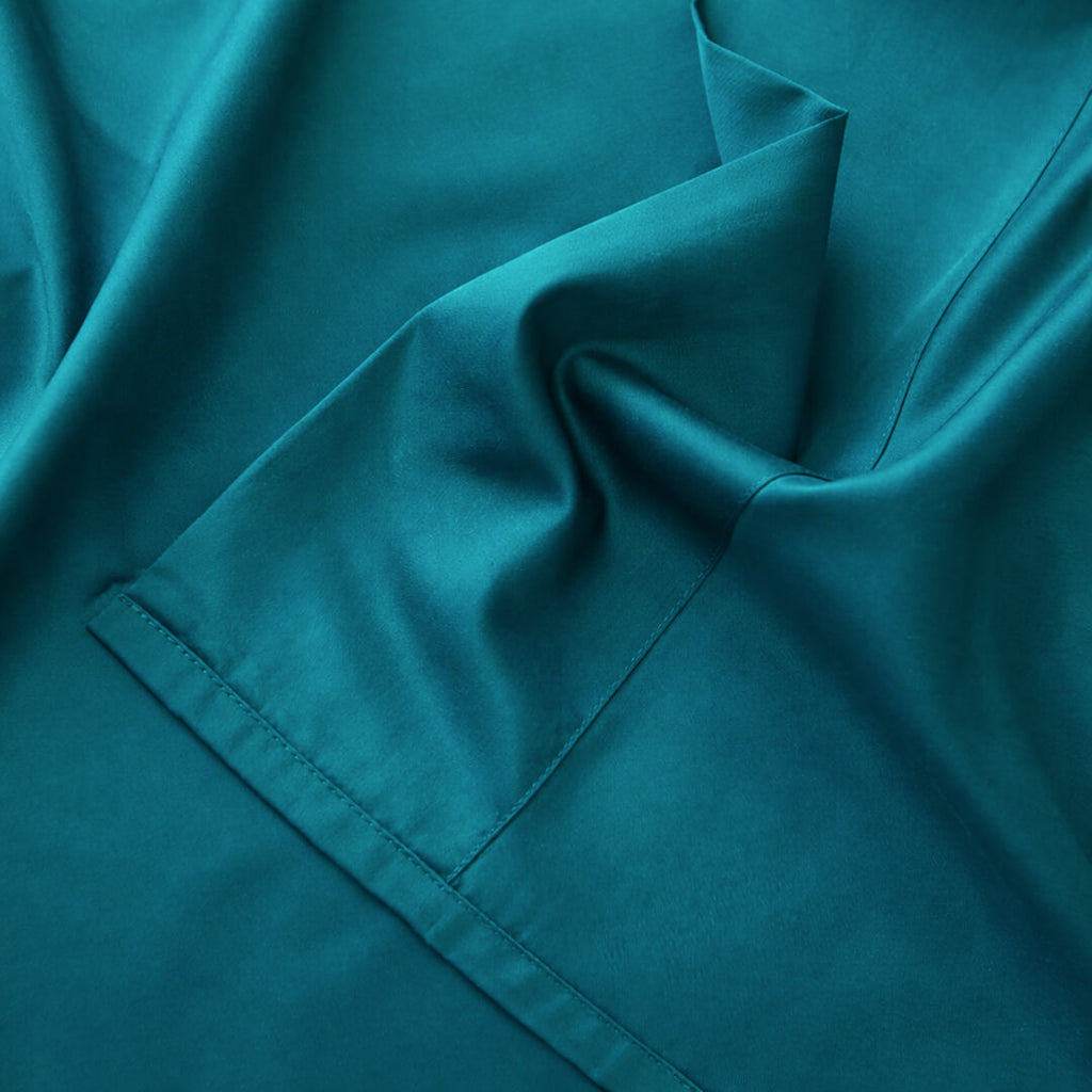 Close-up of teal fabric with a pocket detail