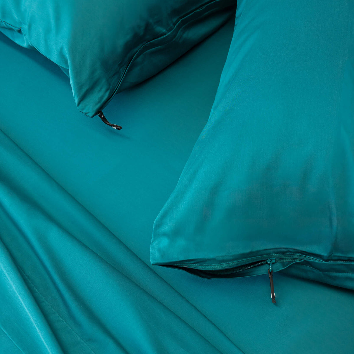 Pair of 2 pillowcases in teal green colour, close up of zip