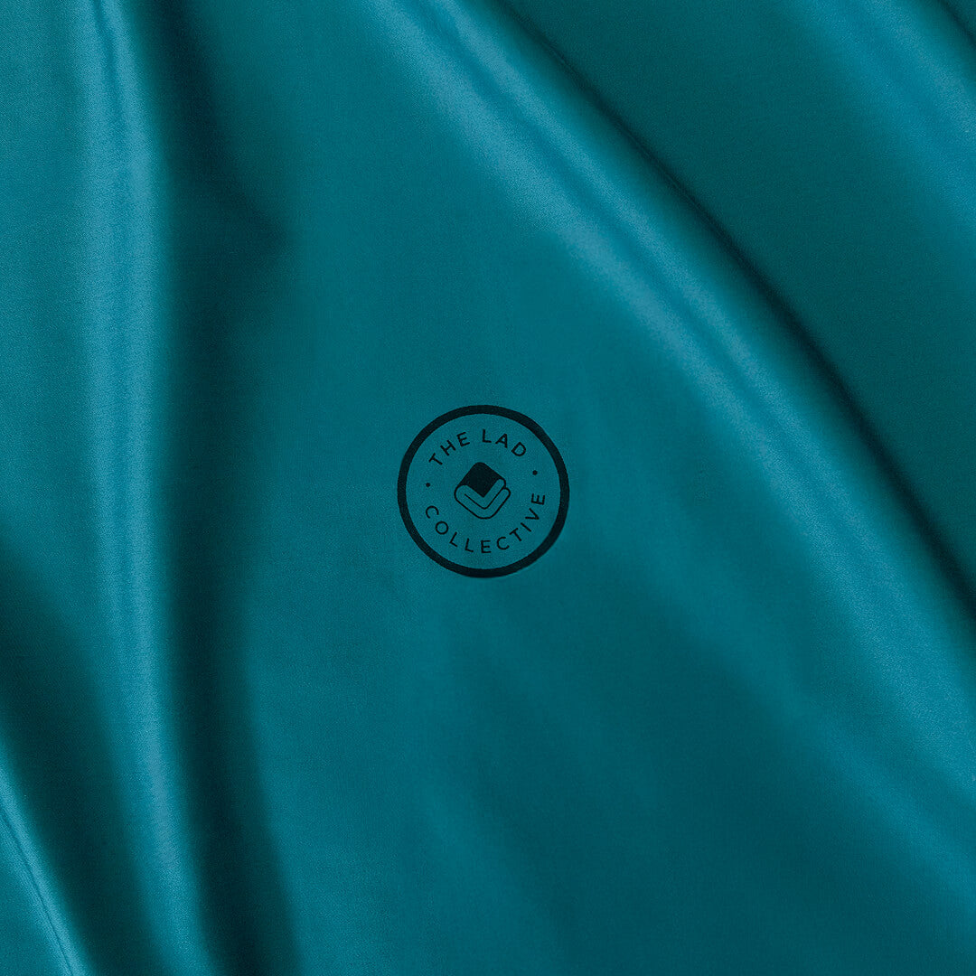 Teal fabric with a black logo in the center