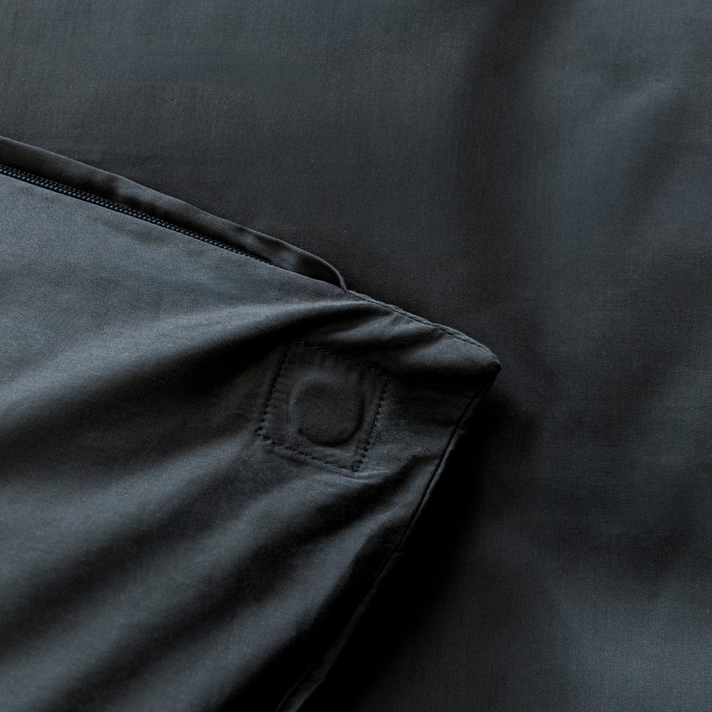 Close-up of a dark fabric with a magnet pocket detail on a matching background