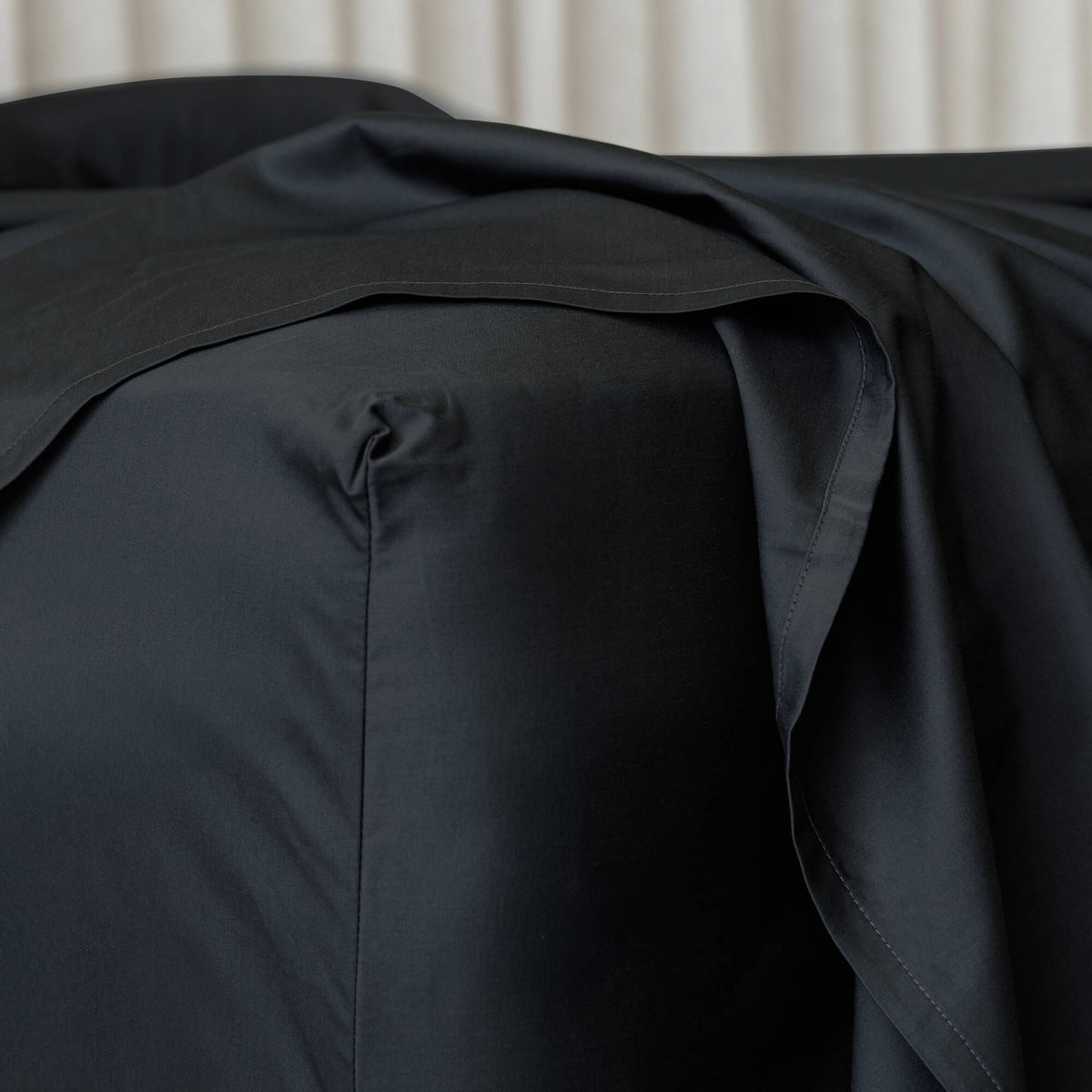 close up of corner of fitted bed sheet in dark charcoal
