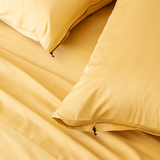 Close-up detail of golden yellow pillowcases featuring hidden zipper closures