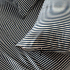 Striped bedding with blue and white horizontal lines on a bed.