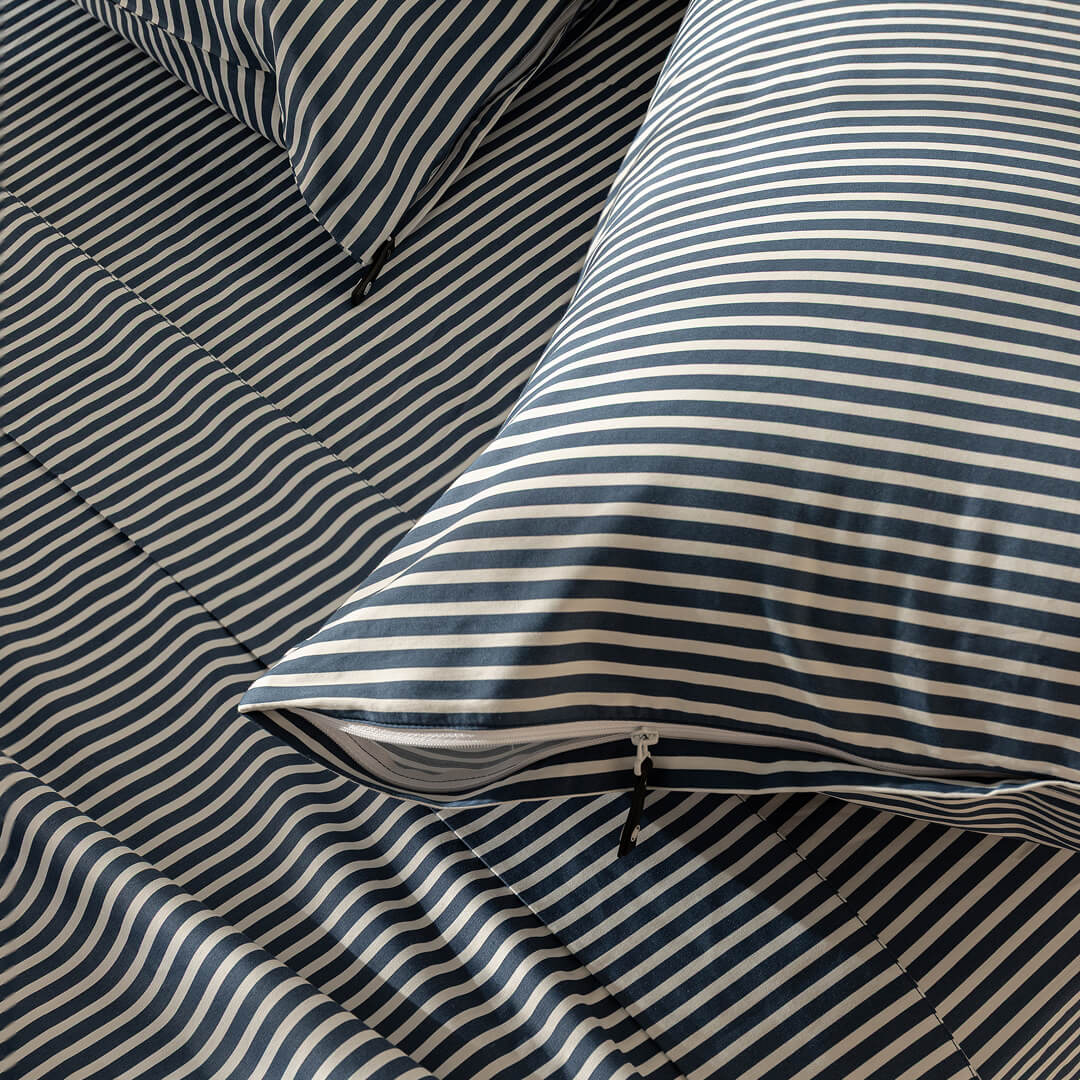 Striped bedding with blue and white horizontal lines on a bed.