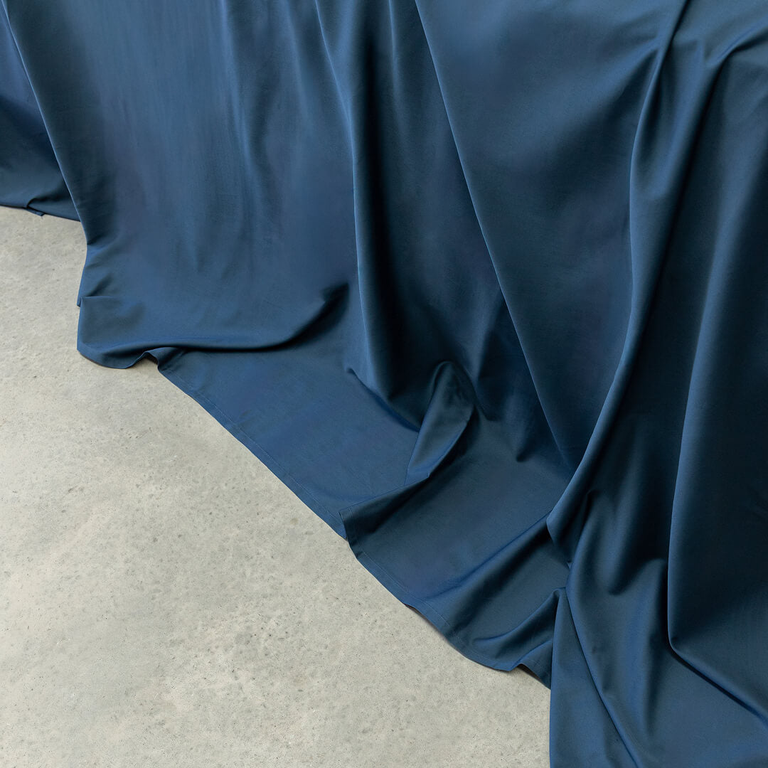 Blue fabric draped over a surface with a neutral background.