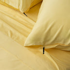 Close-up of yellow bedding with a zipper detail.