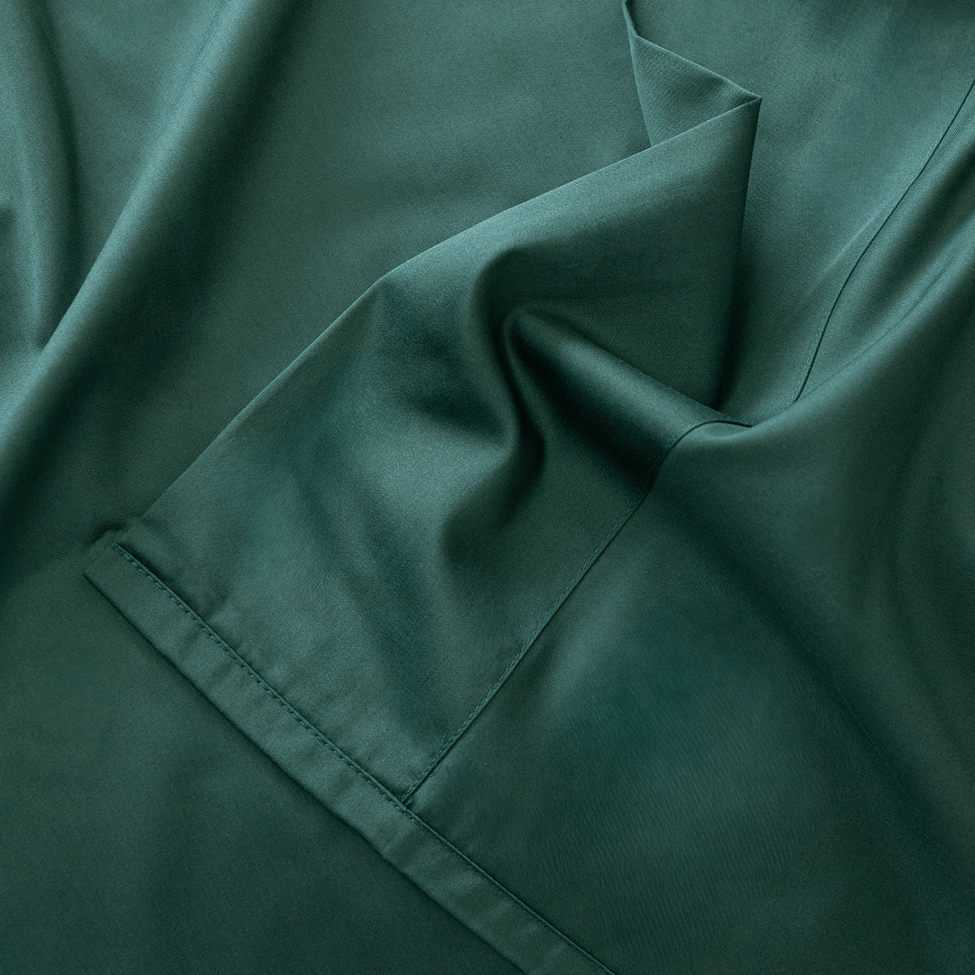 Close-up of dark green fabric with folds.