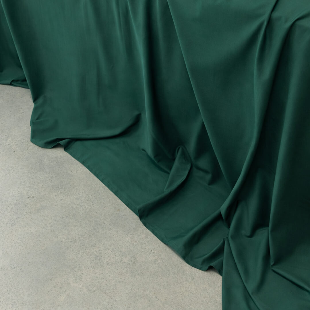 Dark green fabric draped over a neutral surface.