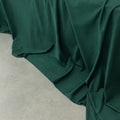 Dark green fabric draped over a neutral surface.