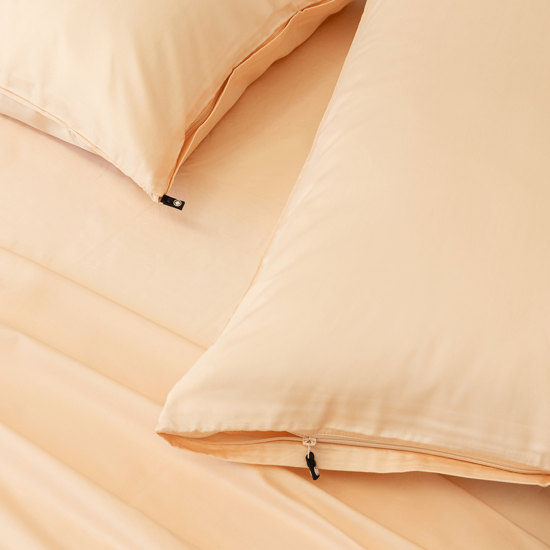 Close-up detail of peach pillowcases featuring hidden zipper closures
