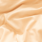 Extreme close-up showing the soft drape and fine weave of peach-colored cotton fabric