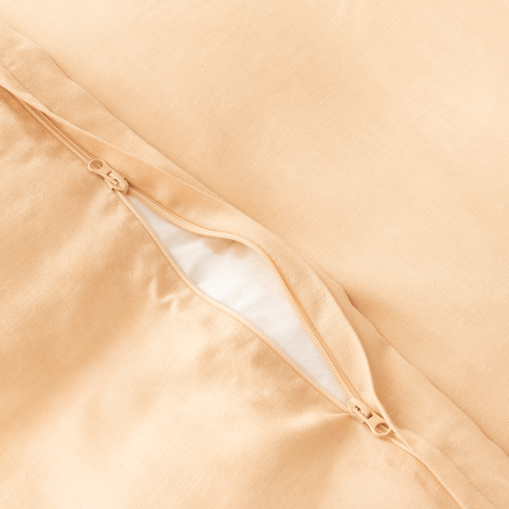 Close-up detail of a peach quilt cover featuring a dual zipper closure