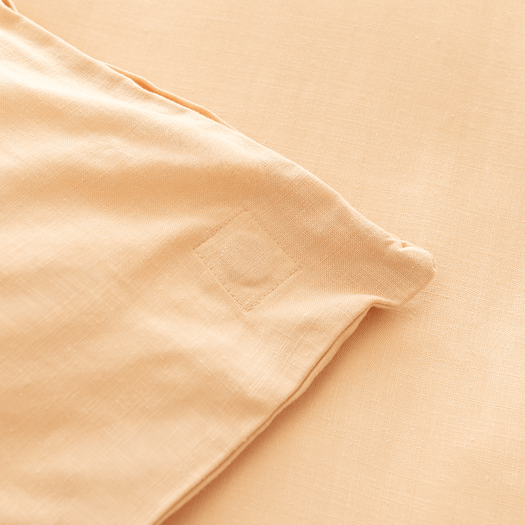 Close-up corner view of peach fabric showing square-stitched corner reinforcement detail