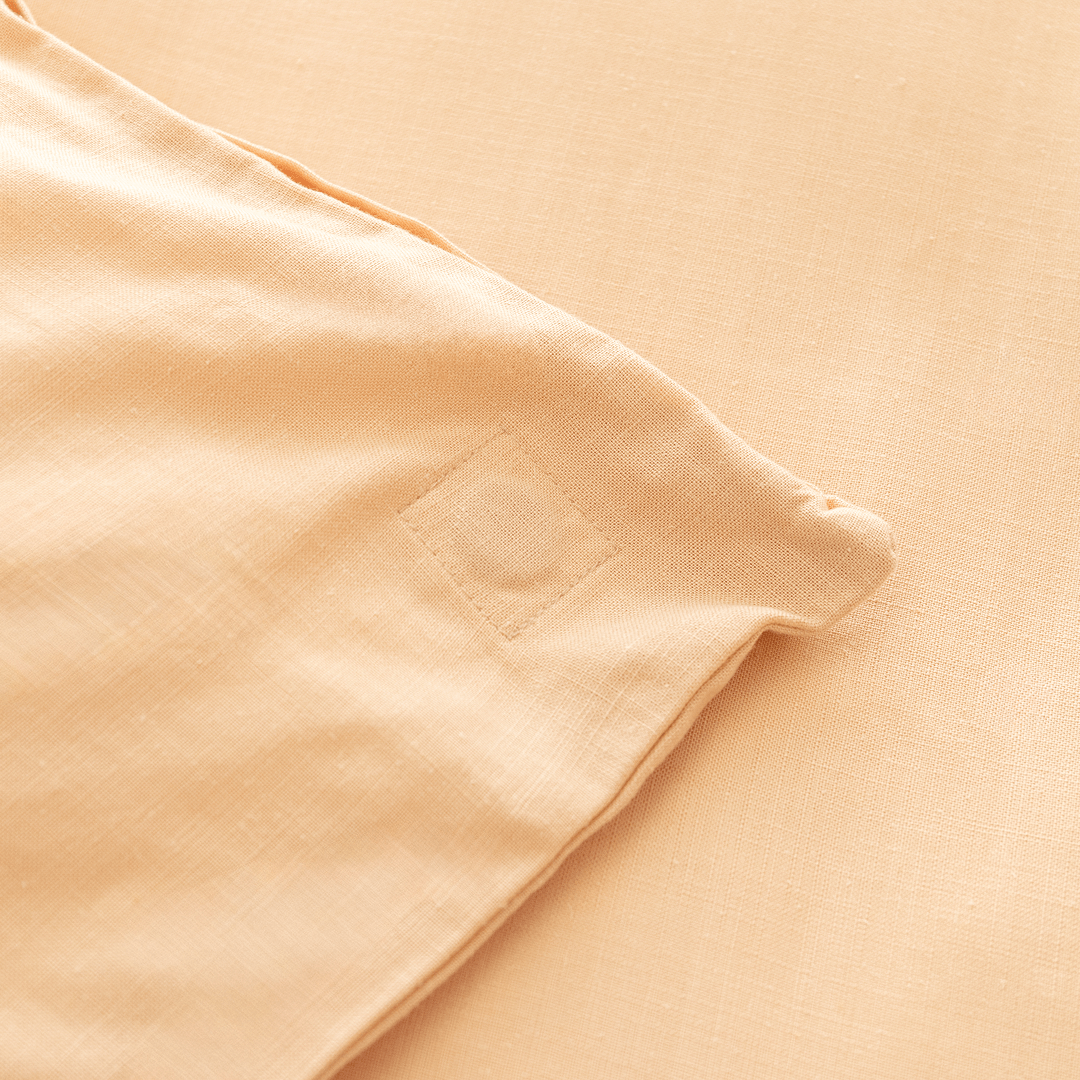 Close-up corner view of peach fabric showing square-stitched corner reinforcement detail