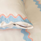 Decorative pillow with wavy pattern on a plain background.