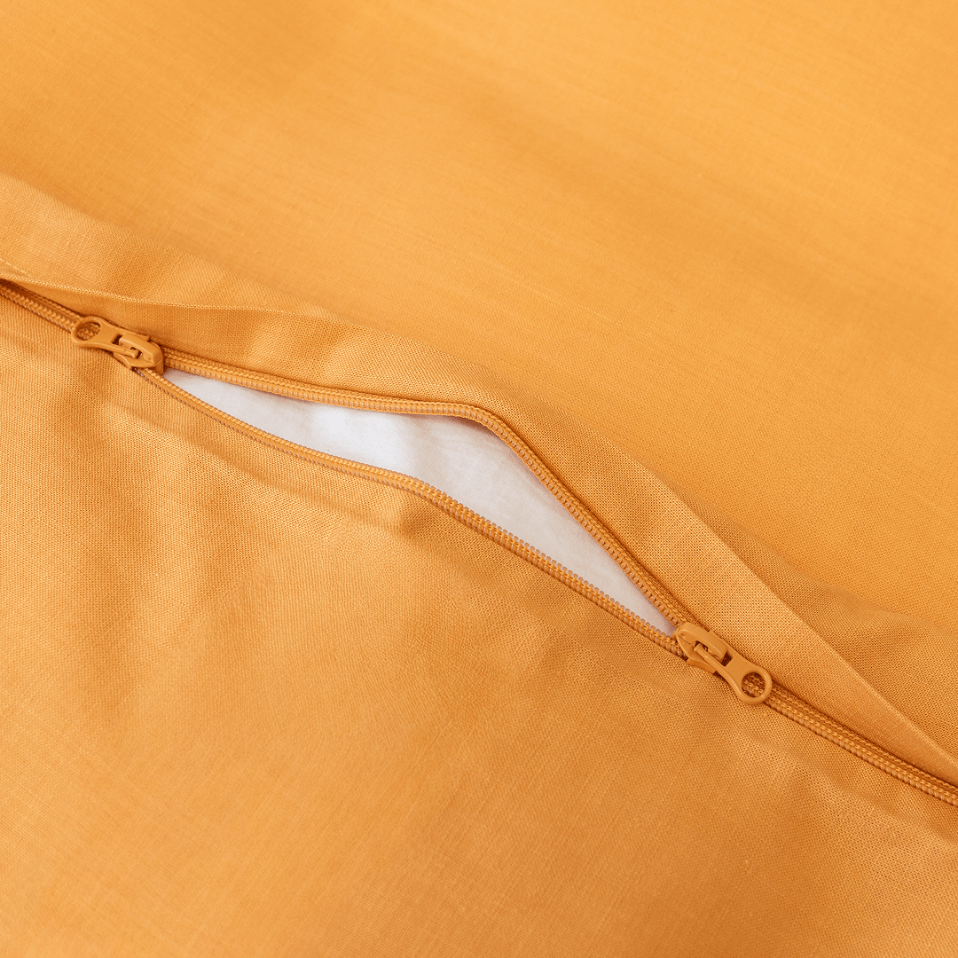 Close-up detail of a mustard yellow quilt cover featuring a dual zipper closure