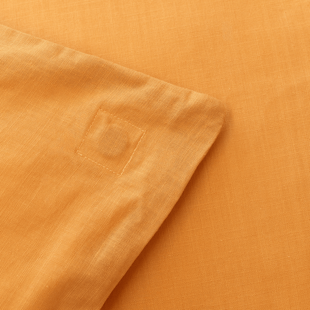Close-up corner view of mustard yellow fabric showing reinforced corner stitching