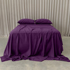 Purple Bed sheets with curtain background.