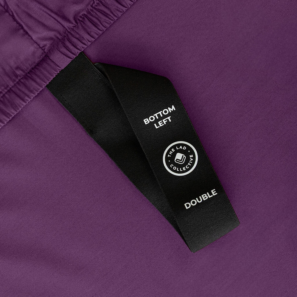 Deep purple fitted sheet labelled corner loop strap.