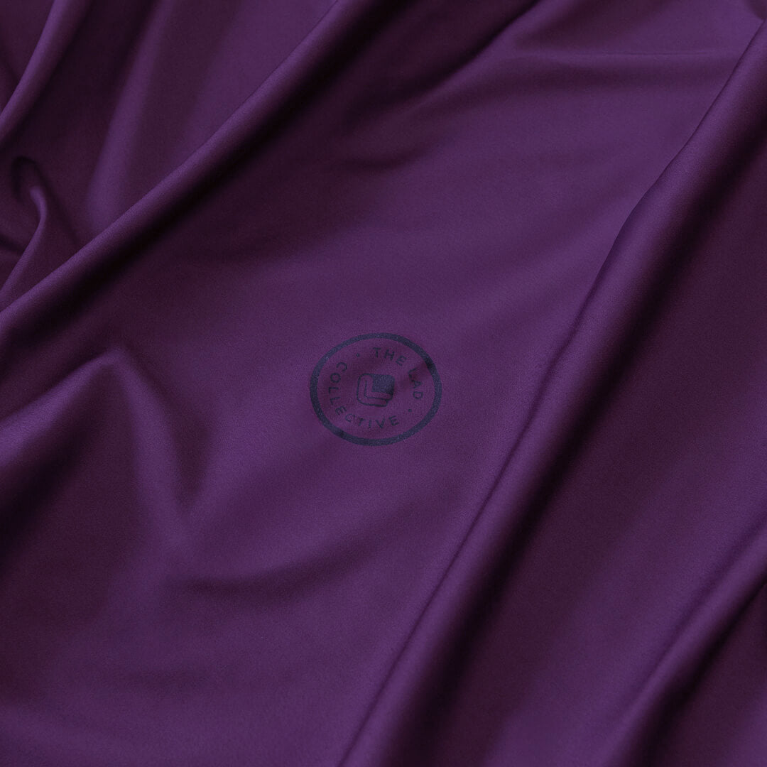 Close-up of purple fabric with a brand logo in the center.