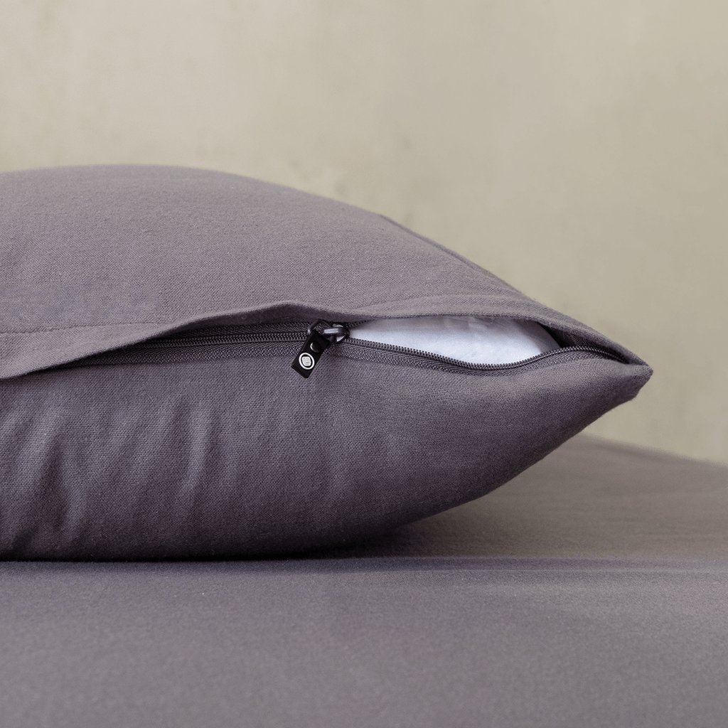 Close-up of a charcoal grey pillowcase featuring a concealed zipper closure, highlighting the secure fastening detail and soft, smooth fabric finish.