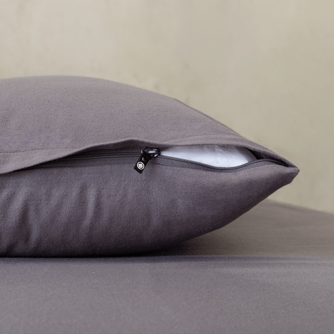 Close-up of a charcoal grey pillowcase featuring a concealed zipper closure, highlighting the secure fastening detail and soft, smooth fabric finish.