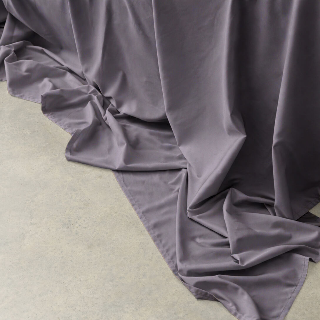 Gray ruffled fabric on a light green surface.