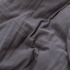 Detailed close-up of dark stone gray stonewashed fabric arranged in natural folds, highlighting its textured finish.