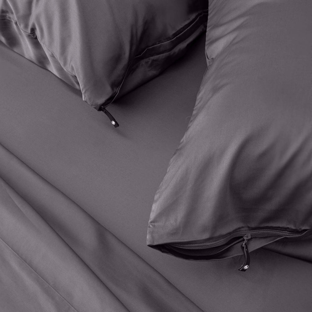 Close up of gray pillows with zip on gray bedding