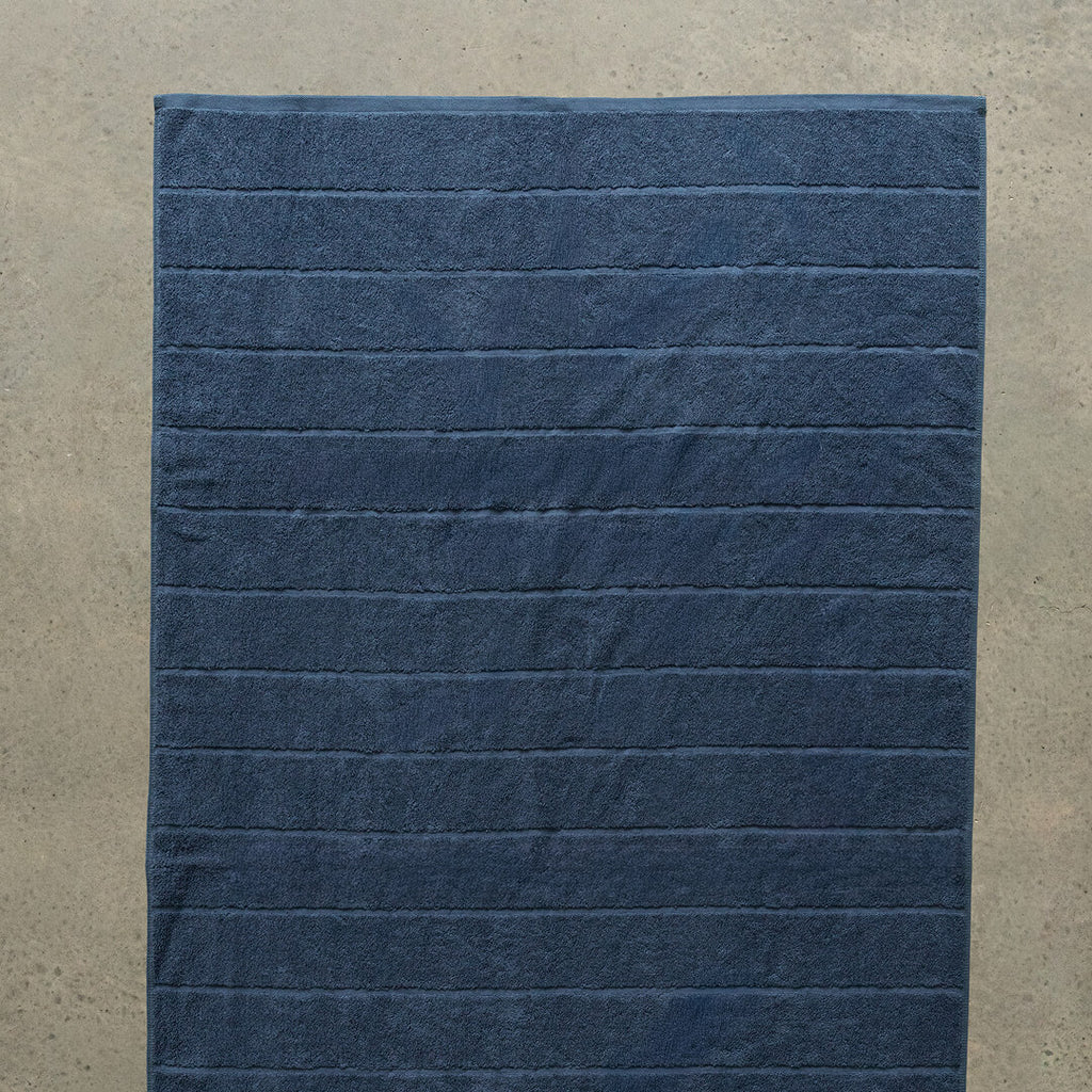 Navy blue textured bath towel laid flat.