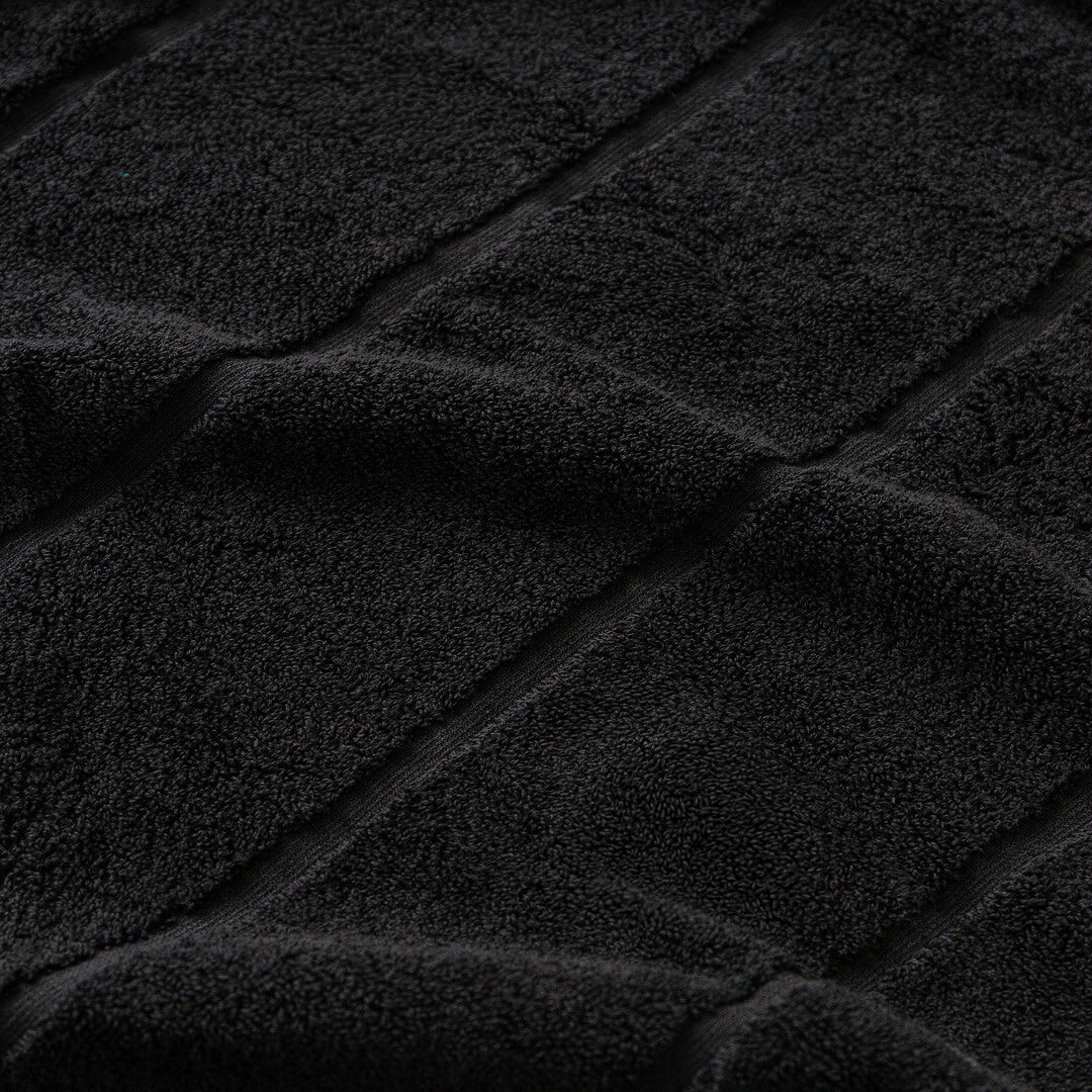 Close-up of black textured towel fabric with diagonal lines.