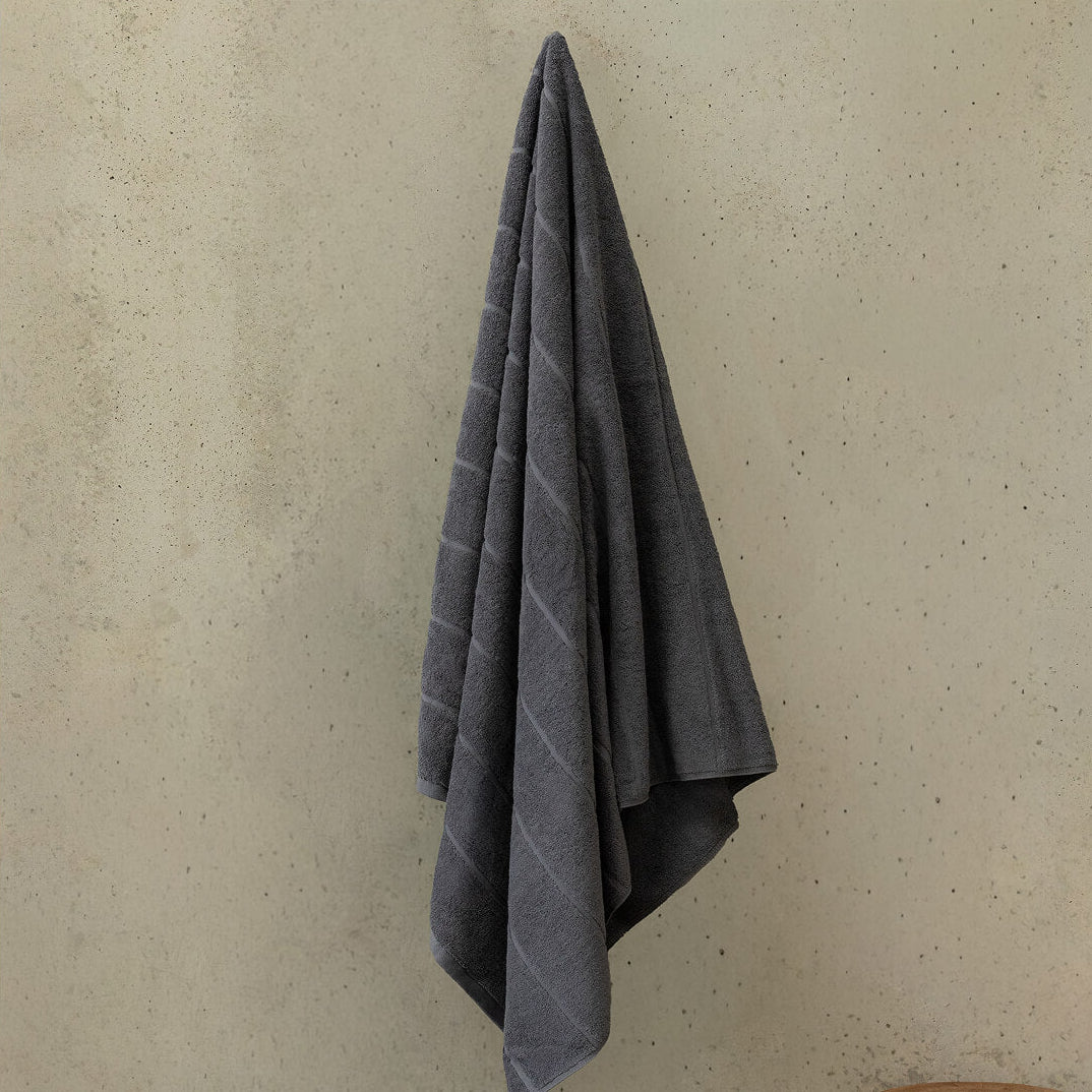 Gray towel hanging on a beige wall.