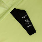 Black labelled corner loop strap with text on a light green fabric background.