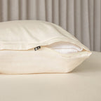 Cream invisible zip pillowcase showing the zip half open on a pillow.