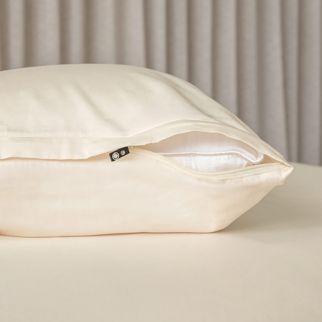 Cream invisible zip pillowcase showing the zip half open on a pillow.